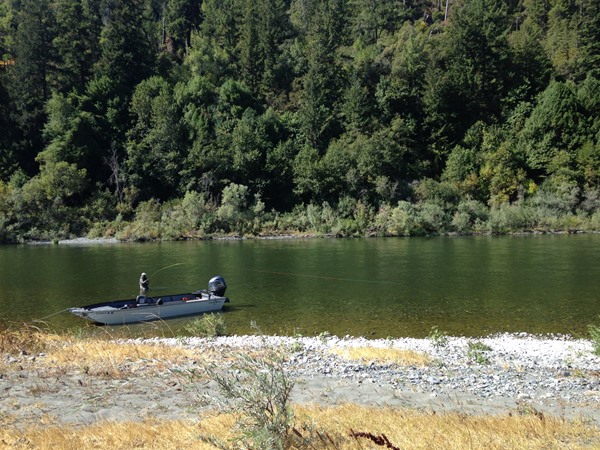 An angler plays a fish near the jet boat